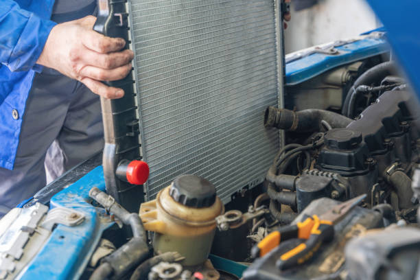 .A man installs a new radiator in a car. Radiator Repair<br />